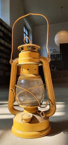 an old yellow lantern is sitting on the floor