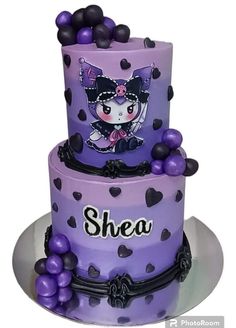 a purple and black cake with an image of a cat on the top is shown