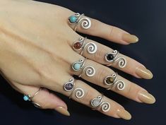 a woman's hand with five different rings on her fingers and one is wearing a ring