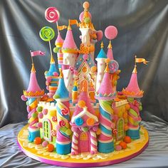 this is a cake made to look like a castle with candy and lollipops