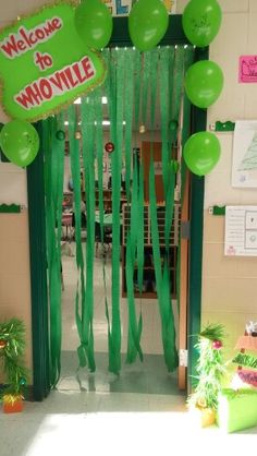 an entrance to a school decorated with green balloons and streamers that say welcome to movillee