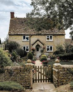 a stone house with a wooden gate leading to it