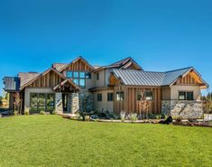 a large house with lots of windows on the front and side of it, surrounded by grass