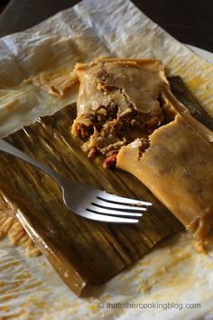 a piece of food on a plate with a fork next to it and some napkins