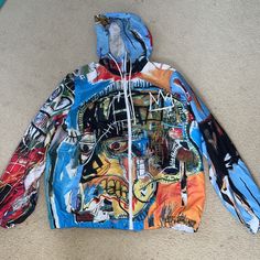 Jean Michel Basquiat + Members Only Zip Up Multicolored Windbreaker Jacket With Interior Mesh Lining. Wearable Art. Size Large. New, Never Worn. Casual Blue Outerwear With Graffiti Print, Hooded Graphic Print Windbreaker For Spring, Hooded Windbreaker With Graphic Print For Spring, Hooded Graphic Print Spring Windbreaker, Blue Long Sleeve Outerwear With Graffiti Print, Multicolor Graffiti Print Winter Outerwear, Multicolor Hooded Outerwear With Graphic Print, Multicolor Graphic Print Hooded Outerwear, Multicolor Graffiti Print Outerwear For Streetwear