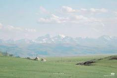 an open field with mountains in the background