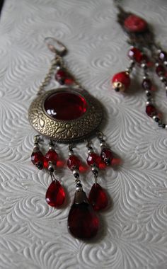 "This listing is for An Art Nouveau Antique 1930's Czech Vibrant Red Color Glass bead, and delicately carved celluloid Festoon Lariat Necklace and Earring Set* A true One of a kind set! The pieces show the patina of time, which makes this a testimonial of a past era. Glamorous and classic chic. Here are the details of this specific gem exactly as shown on pictures: kindly regard that this piece does show wear on the largest glass centerpiece, but otherwise all else is in superb pre_loved conditi Antique Red Dangle Jewelry, Vintage Wedding Jewelry With Dangling Beads, Vintage Beaded Lariat Jewelry, Vintage Red Jewelry With Dangling Beads, Handmade Vintage Long Drop Jewelry, Vintage Red Necklace With Dangling Beads, Red Vintage Necklace With Dangling Beads, Red Victorian Jewelry For Vintage Collection, Red Bohemian Necklace For Formal Occasions