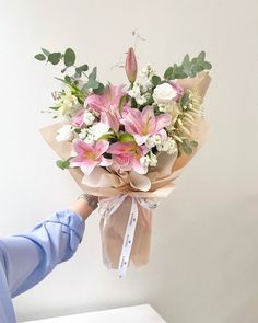 someone is holding a bouquet of flowers in their hand while wearing blue gloves and rubber gloves