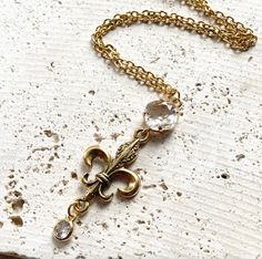 This beautiful gold hand casted fleur de lis necklace has a vintage vibe to it. 18” non tarnish chain with a 2.5” pendant drop Gold Dangle Jewelry With Antique Finish, Elegant Gold Necklaces With Antique Finish, Elegant Gold Necklace With Antique Finish, Elegant Tarnish-resistant Bronze Necklace, Gold Hand, Gold Hands, Vintage Vibe, Vintage Vibes, It Cast