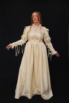 This beautiful Renaissance-style dress is made with taffeta creme ivory fabric and ivory and gold brocade fabric. The chamise dress is made from transparent opaque organza fabric with handmade beads and pearl embroidery. This price includes the dress, the detachable sleeves, and the CHEMISE dress. available in size 10 UK, 8 USA, M  Suitable for the following measurements : High 168 cm Bust 92-98 cm          36.2- 38.5in Waist 74-80 cm            29.1- 31.4 in Arm perimeter 28-32 cm Fitted Taffeta Gown For Wedding, Fitted Taffeta Dress For Wedding, Fitted Taffeta Wedding Dress, Fitted Bodice Taffeta Corset Dress For Wedding, Taffeta Ball Gown Wedding Dress, Taffeta Dresses For Debutante Ball, Beige Fitted Dress For Costume, Fitted White Vintage Dress For Fancy Dress Event, Fitted White Vintage Dress For Fancy Dress