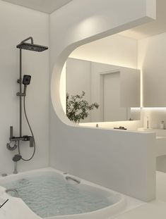 a bath tub sitting under a bathroom mirror