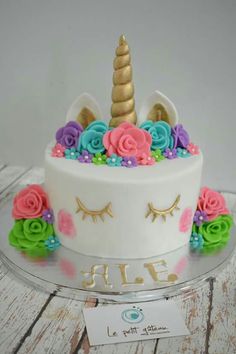 a cake decorated with flowers and a unicorn's horn