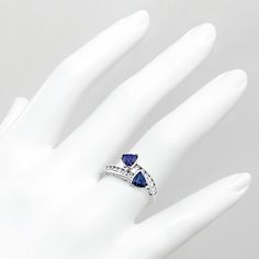 This beautiful 2-stone cocktail ring is adorned with trillion-cut VS-clarity blue sapphires and round diamonds. The gemstones weigh a total of 1.42ct. This uniquely designed ring is available in all precious metals. Formal Trillion-cut Sapphire Ring With Accent Stones, Fine Jewelry Sapphire Trillion Cut, Classic Trillion Cut Sapphire Jewelry, Luxury Sapphire Ring With Trillion-cut Diamond, Sapphire Gemstone Ring, Trillion Cut, Blue Sapphire Diamond, Sapphire Diamond, Cocktail Rings, Diamond White