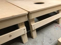 two unfinished wooden tables and stools sitting on the floor next to each other in a room