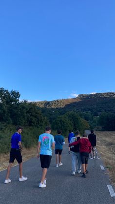 group of people walking down the road on a clear day with blue sky in the background