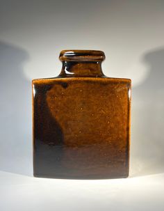 a brown vase sitting on top of a white table