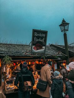 people are standing in front of a food stand