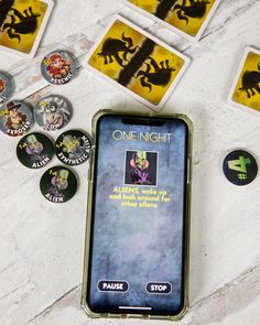 a cell phone sitting on top of a table next to some buttons and magnets