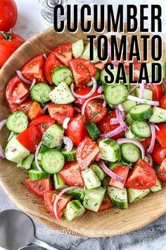 a wooden bowl filled with cucumber tomato salad