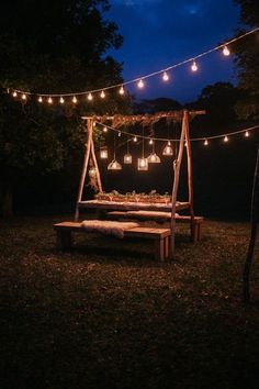 a wooden bench with lights hanging from it's sides in the night time,