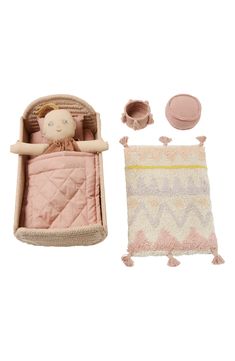 a baby doll is laying in a crib next to a blanket