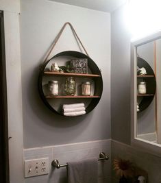 a bathroom with two round shelves on the wall