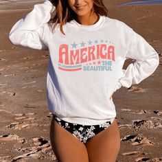 Celebrate the 4th of July in our retroAmerica The Beautiful sweatshirt. Perfect for the beach, summer BBQs and campfires on summer evenings.  A sturdy and warm sweatshirt bound to keep you warm in the colder months. A pre-shrunk, classic fit sweater that's made with air-jet spun yarn for a soft feel and reduced pilling. * 50% cotton, 50% polyester * Pre-shrunk * Classic fit * 1x1 athletic rib knit collar with spandex * Air-jet spun yarn with a soft feel and reduced pilling * Double-needle stitch American Flag Print Cotton Top For Beach, White American Flag Print Top For The Beach, White American Flag Print Top For Beach, White American Flag Print Tops For Beach, White Tops With American Flag Print For Beach, Casual American Flag Print Top For Vacation, Patriotic Tops For 4th Of July Vacation, Patriotic Cotton Tops For Vacation, Patriotic Beach Tops With Flag Print