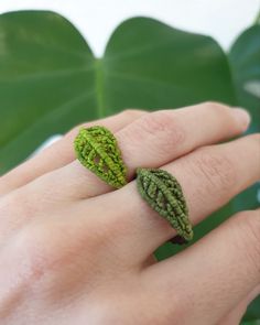 a person's hand with a ring made out of leaves on top of it