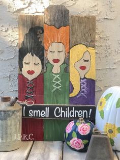 a wooden sign that says i smell children on it next to some pumpkins and other decorations