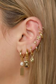 a close up of a person's ear with two different earrings on top of it