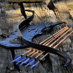 an arrow and bow rest on a piece of wood