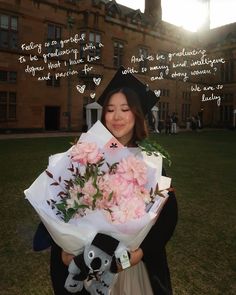 a woman holding flowers and a stuffed animal in front of a building with words written on it