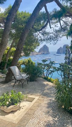 an outdoor patio with chairs and trees overlooking the ocean