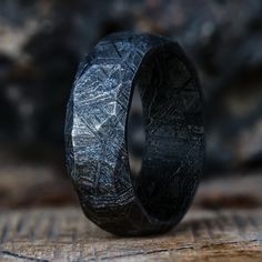 It's time that one of our favorite finishes came to one of our favorite rings. The obsidian meteorite ring shows our classic meteorite ring in a new light. Handcrafted from a solid piece of meteorite, a unique pattern is applied by adding a random assortment of facets, by hand, to create a truly one of a kind ring.  Ho Cool Wedding Rings Unique, Unique Wedding Rings For Him, Unique Men’s Wedding Rings, Men’s Rings, Meteorite Ring Men, Meteorite Wedding Ring, Unique Mens Wedding Bands, Faceted Wedding Bands, Meteorite Engagement Ring