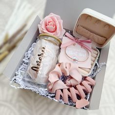 a box filled with pink and white items next to a flower on top of a table