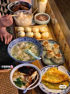 a table topped with bowls and plates filled with different types of food on top of it