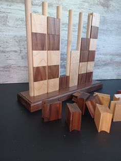 several pieces of wood sitting on top of a black table next to blocks of wood