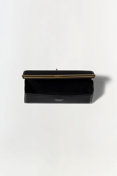 PRE-FALL 2024 WOMEN'S COLLECTION The Rolo Clutch in Black. This sleek bag features a streamlined design accentuated by a chic gold accent stripe. Its minimalistic elegance is perfect for any formal occasion. The long, delicate chain allows for versatile wear, letting you carry it as a shoulder bag or tuck the chain inside for a classic hand-held look. Elegant Structured Clutch For Formal Occasions, Elegant Structured Formal Clutch, Modern Business Clutch With Gold-tone Hardware, Modern Structured Clutch For Formal Occasions, Modern Black Business Clutch, Formal Structured Clutch, Chic Rectangular Clutch For Office, Classic Clutch With Detachable Strap In Rectangular Case, Classic Clutch With Detachable Strap And Rectangular Case