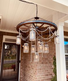 an outdoor chandelier with mason jars hanging from it