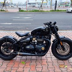 the motorcycle is parked on the brick sidewalk