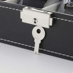 a close up of a suitcase with a key on it's handle and two watches in the background