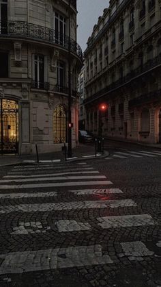 an empty city street at night with the lights on