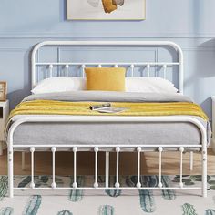 a white metal bed frame with yellow pillows and blankets on it in a blue bedroom