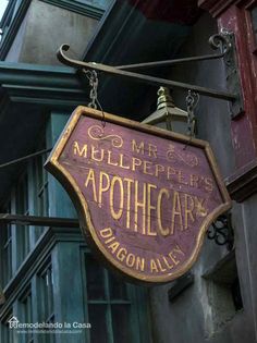 a sign hanging from the side of a building that says, mullepeers apothecar dragon alley