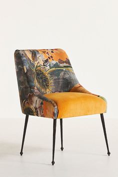 an upholstered chair with yellow fabric and black legs is shown in front of a white background