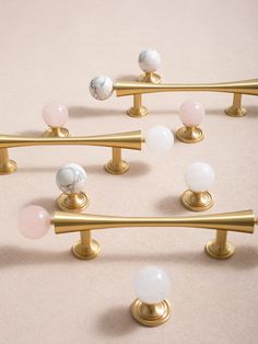 several gold handles and knobs with marble balls on them