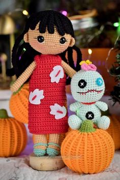 a crocheted doll and a stuffed animal are sitting on top of pumpkins