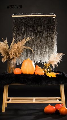 a black chair with some pumpkins and other decorations on top of it in front of a black background