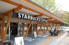 the outside of starbucks coffee with people sitting at tables