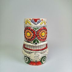 a colorfully decorated ceramic vase sitting on top of a table